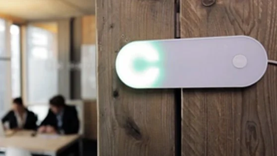 White Clay hardware with a green light on a wooden wall.