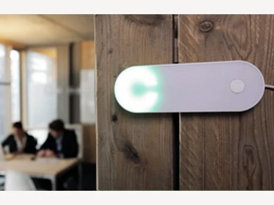 Witte Clay-hardware met groen licht op een houten wand.