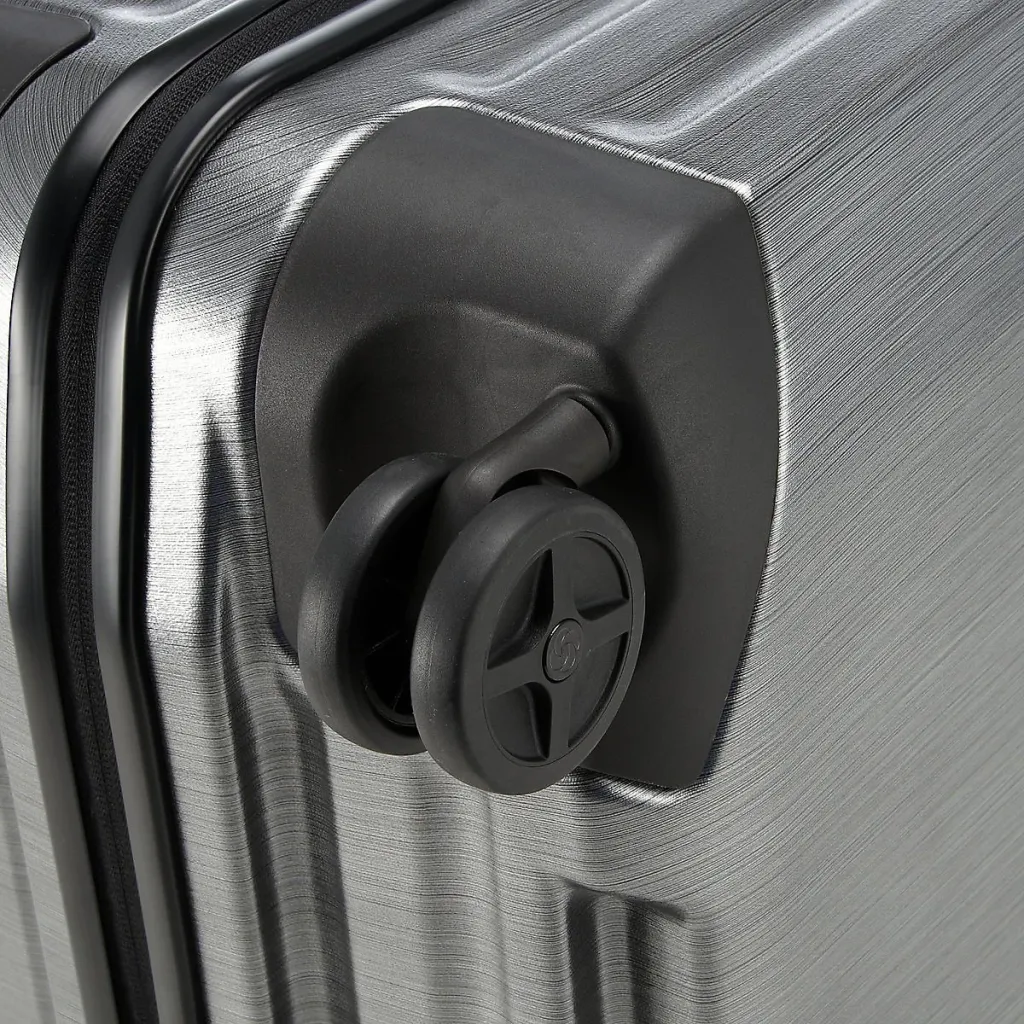 Detail of the wheel and ribbed corner of a Samsonite Inova suitcase.