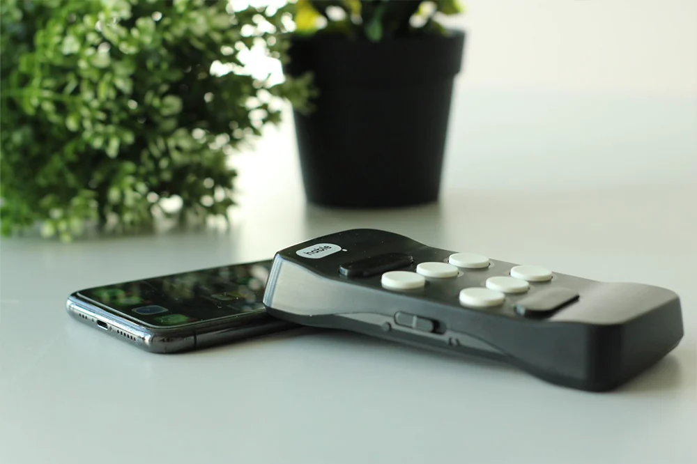 Hable One naast een smartphone op een tafel bij het raam.