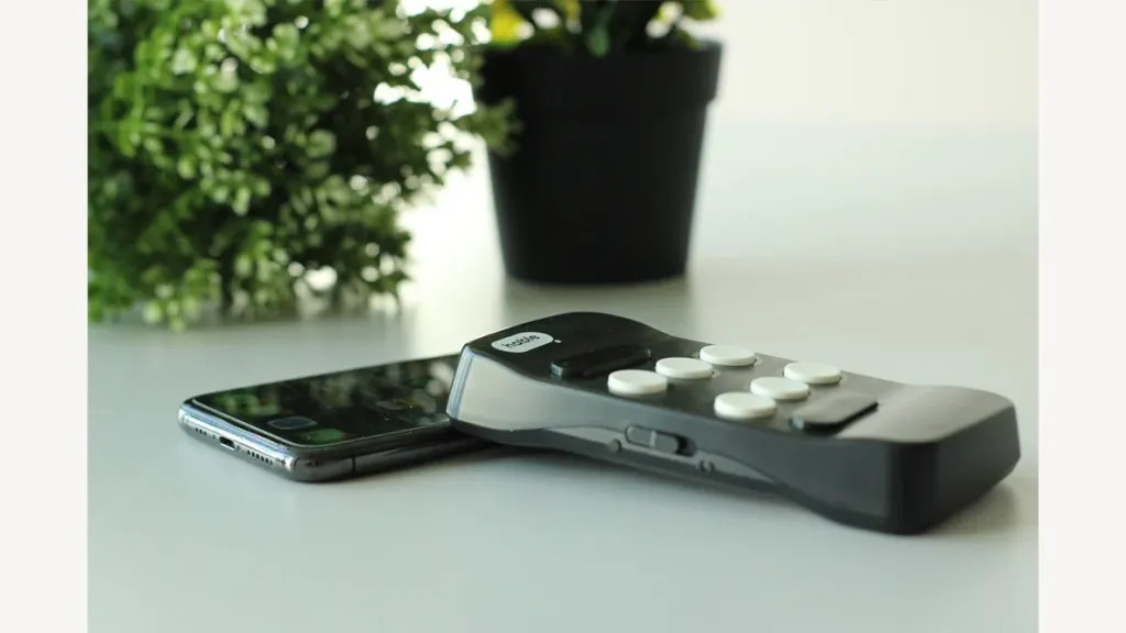 Hable One naast een smartphone op een tafel bij het raam.