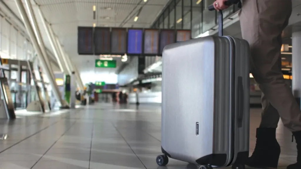 A traveller with a Samsonite Inova suitcase at an airport.
