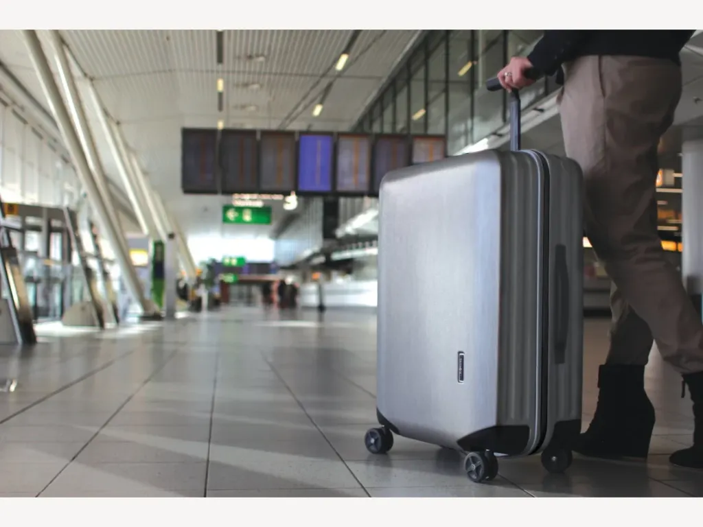 Een reiziger met een Samsonite Inova-koffer op een luchthaven.