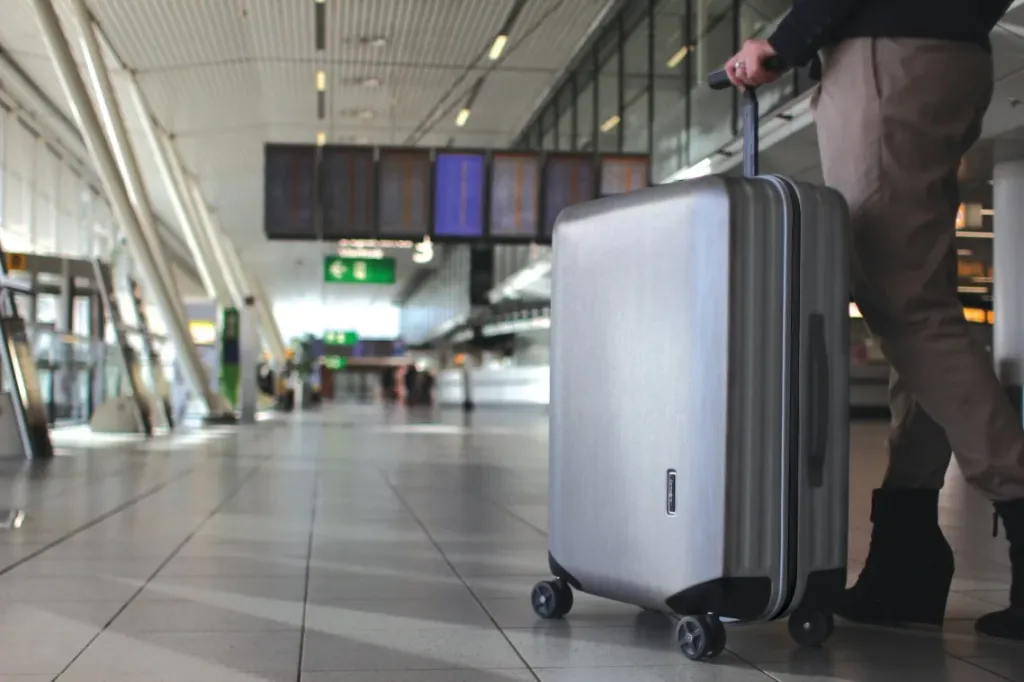 A traveller with a Samsonite Inova suitcase at an airport.