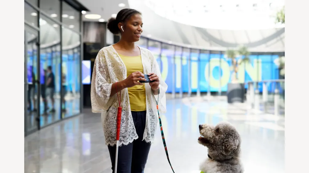 Een gebruiker bedient Hable One naast een geleidehond op een station.