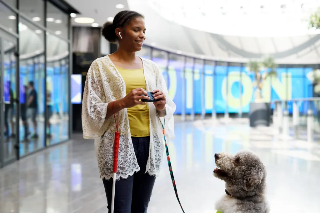 Een gebruiker bedient Hable One naast een geleidehond op een station.