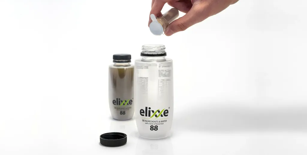 Eine Hand fügt einer offenen Elixxe-Flasche eine Zutatenkapsel hinzu.