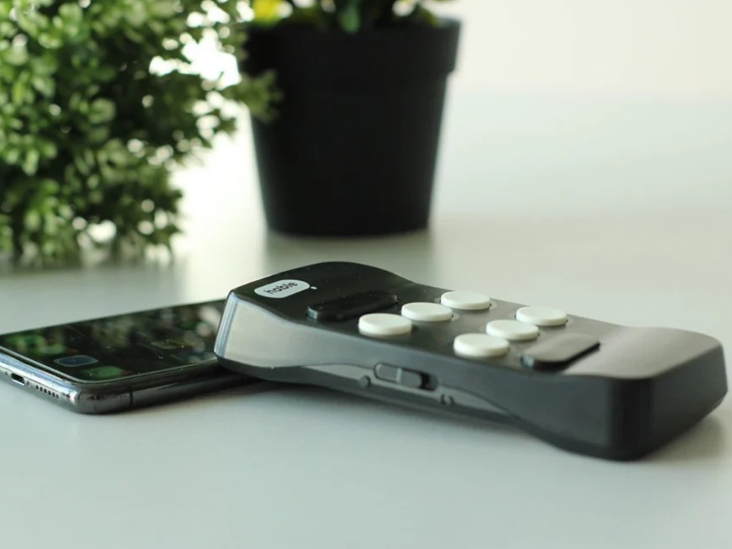 Hable One naast een smartphone op een tafel bij het raam.