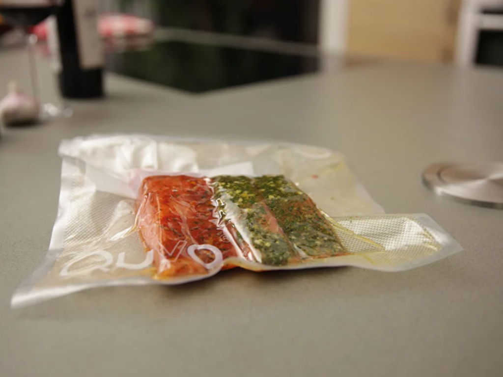 Eine vakuumverpackte Portion Lebensmittel auf der Arbeitsfläche neben Quva.
