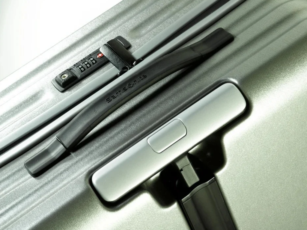 Detail des Schlosses und Griffs eines Samsonite Inova‑Koffers.